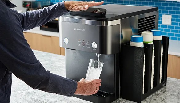 woman dispensing water from a countertop ice and water dispenser